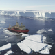 The R/V Nathaniel B. Palmer in front of the icy cliffs of Thwaites Glacier. Fragments of sea ice sit around the boat.